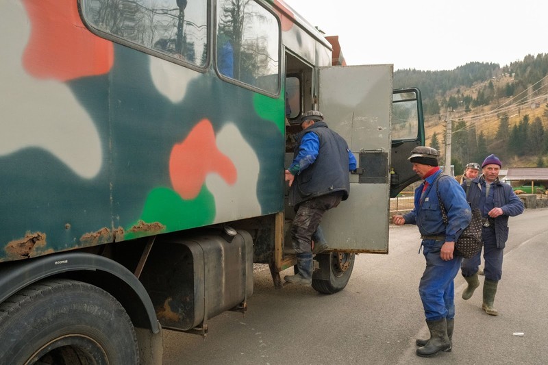 Minerii se urcă în Crucea în camioanele care îi duc pe platforma minieră