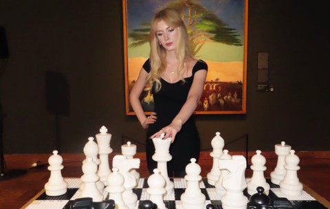 Hannah Sayce joacă șah cu niște piese de dimensiuni mai mari.