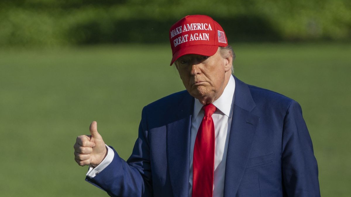 Donald Trump cu o șapcă roșie pe care scrie mesajul „Make America Great Again” și cu degetul mare ridicat Donald Trump, se îndreaptă spre Casa Albă la sosirea sa la Washington DC din New Jersey, pe 21 iunie 2025