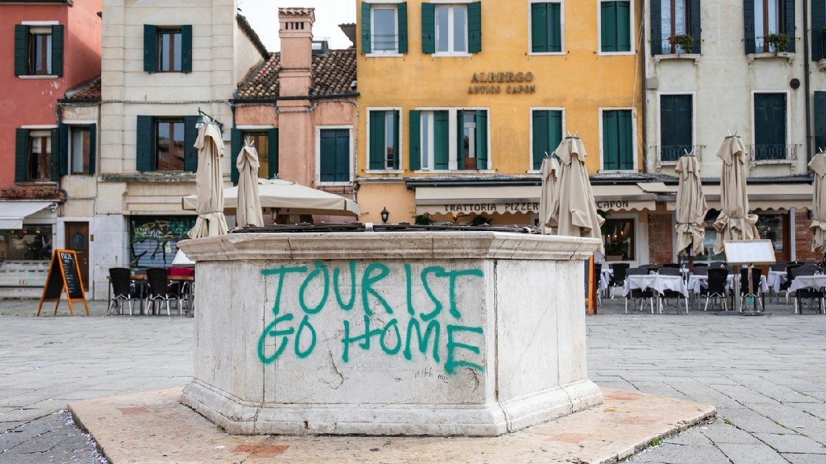 Protest împotriva turismului excesiv, slogan pulverizat pe o fântână, Campo Santa Margerita, Veneția, Italia, Europa