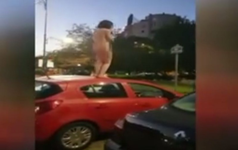VIDEO/ O femeie s-a dezbrăcat în pielea goală și s-a urcat pe o mașină, în București