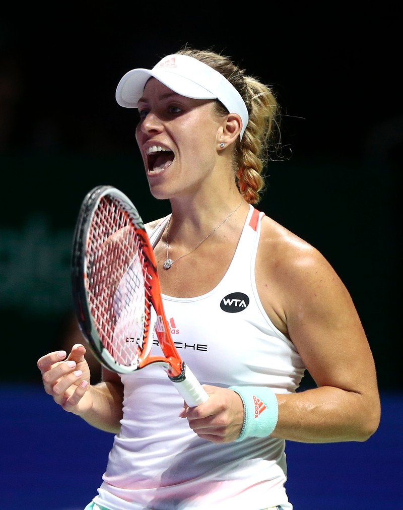 epa05602149 Angelique Kerber of Germany celebrates her win over Simona Halep of Romania during their Red Group round robin singles match of the BNP Paribas WTA Finals 2016 held at the Indoor Stadium in Singapore, 25 October 2016. EPA/WALLACE WOON