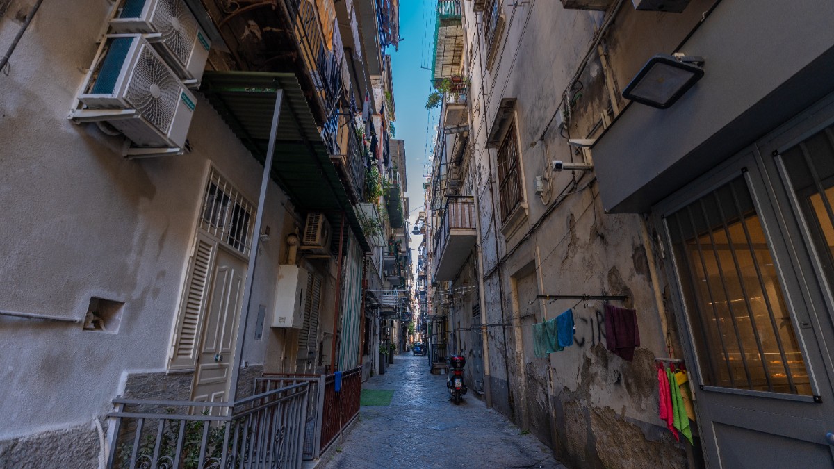 O stradă întunecată din Italia, unde blocurile sunt foarte apropiate, atât devapropiate în cât lumina naturală nu mai pătrunde