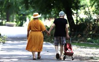 Doi pensionari imbracati frumos merg pe strada tinându se de mana