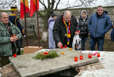 Oamenii aprind o lumânare pentru oamenii incinerați și a căror cenunșă a fost aruncată la gura de canal din Popești-Leordeni.