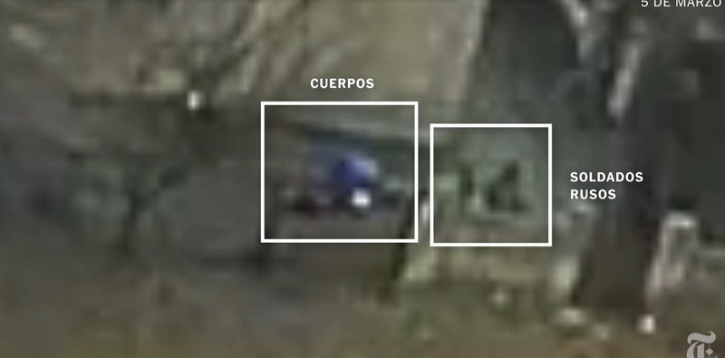Captură video cu ucraineanul în hanorac albastru, la pământ, și soldați ruși lângă el.