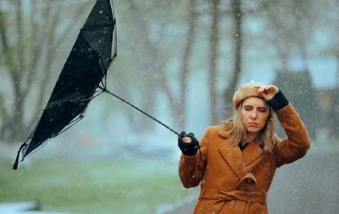 Femeie cu o umbrelă întoarsă de vânt. Persoană nefericită care suferă din cauza vremii furtunoase