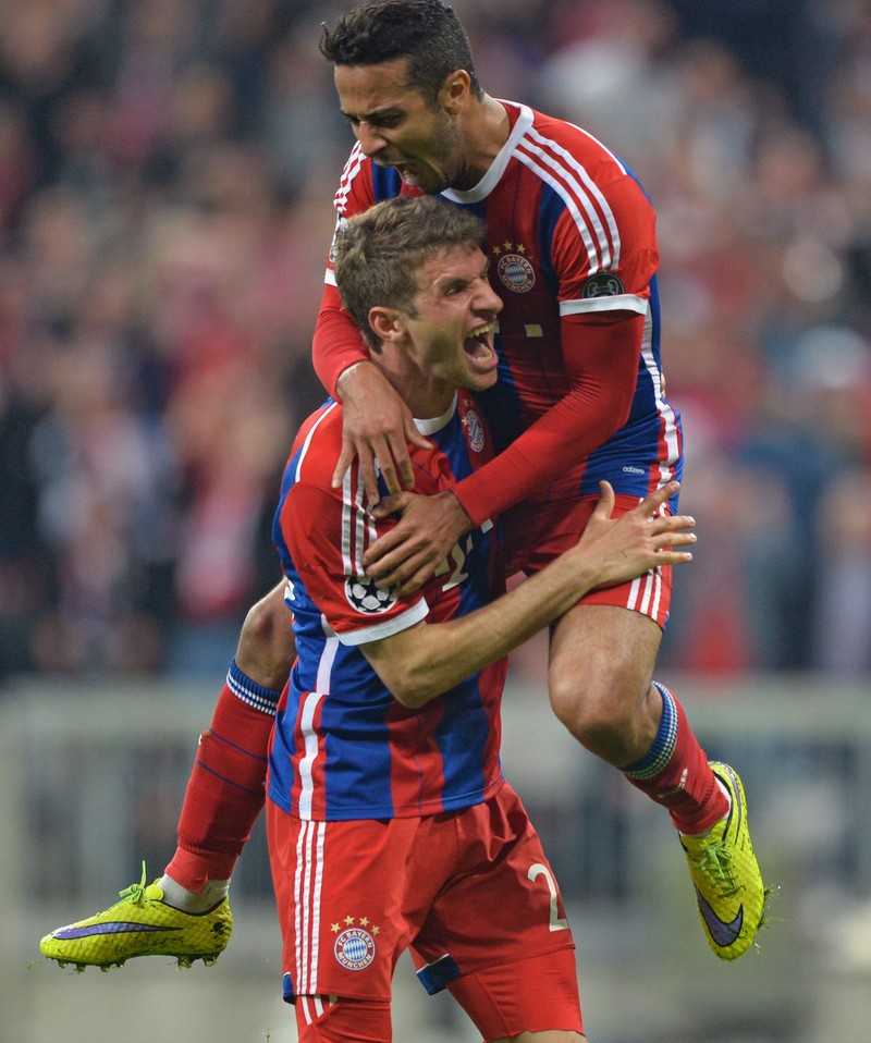 epa04715071 Bayern Munich's Thomas Mueller (bottom) celebrates scoring the 4-0 goal with teammate Thiago Alcantara (top) during the UEFA Champions League quarter final second leg soccer match between FC Bayern Munich and FC Porto at Allianz Arena stadium in Munich, Germany, 21 April 2015. EPA/PETER KNEFFEL