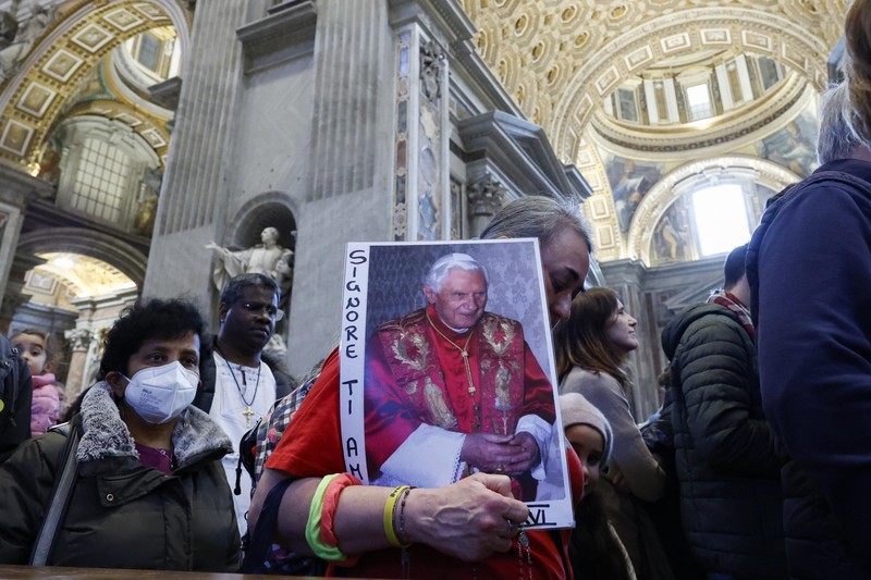 Portretul fostului suveran pontif, în mâinile unui credincios care a venit să aducă un ultim omagiu | Foto: EPA