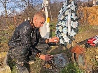 Marius aprinde o lumânare la mormântul tatălui său