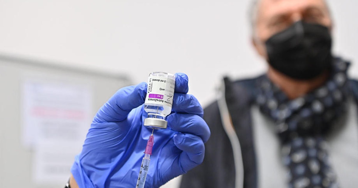 Irlanda dublează capacitatea sistemului de Ambulanță pentru a vaccina oameni acasă. Doctor ce extrage vaccinul din fiolă și o persoană în vârstă în fundal