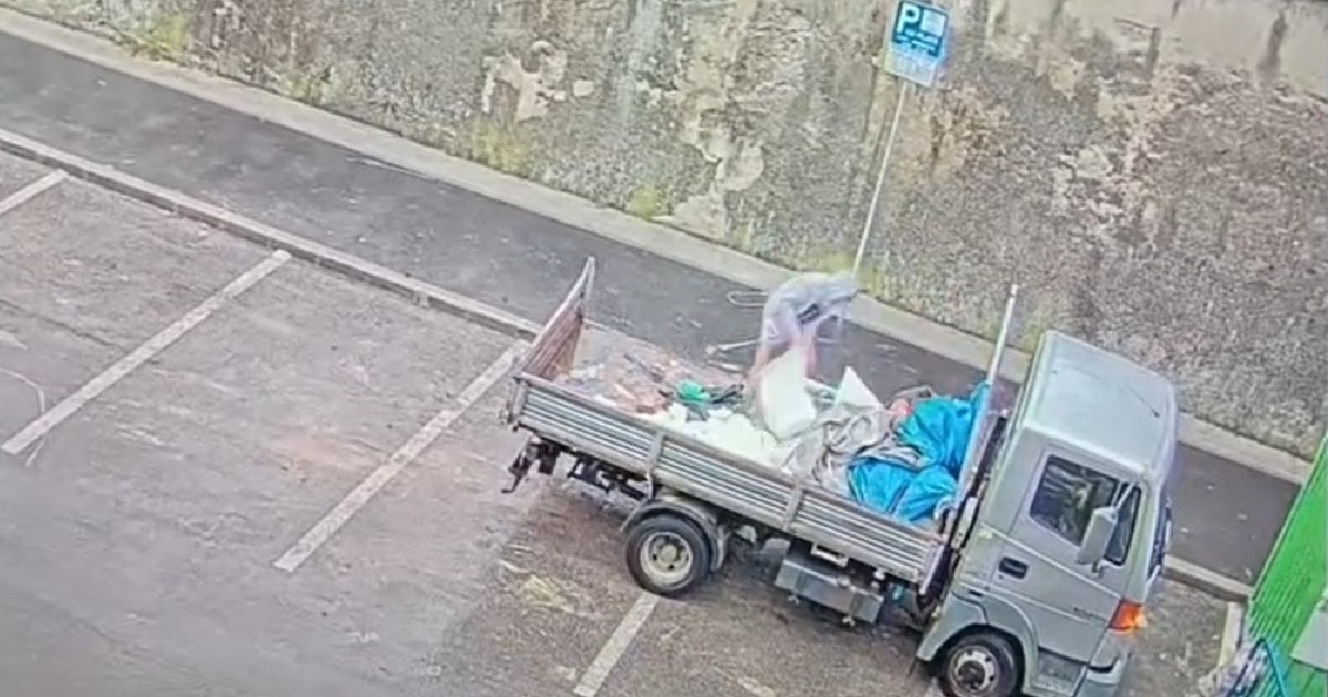 Doi bărbați aruncă molozul dintr-o camionetă, pe o stradă din Cluj