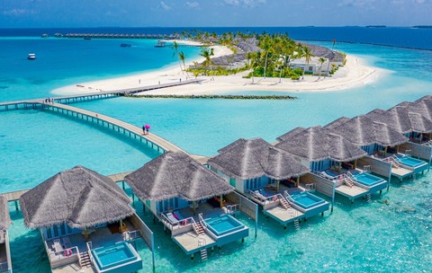 Imagine aeriană asupra unor spaţii de cazare deasupra mării în Insulele Maldive.