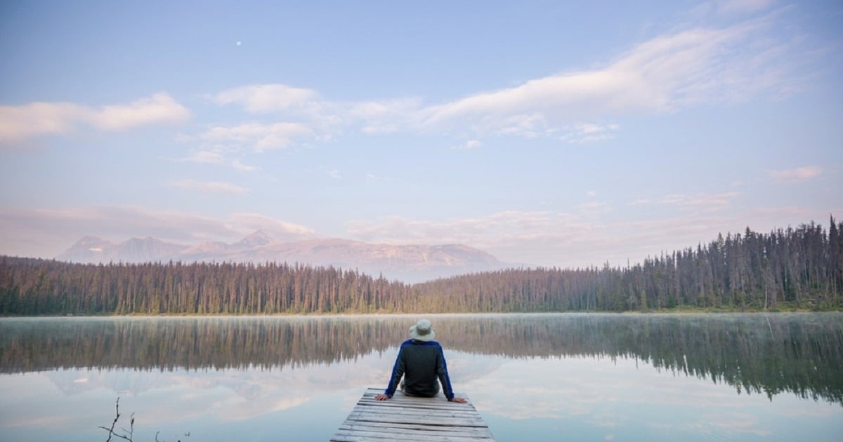 Ce înseamnă când visezi lac - Un barbat sta pe un ponton pe malul unui lac