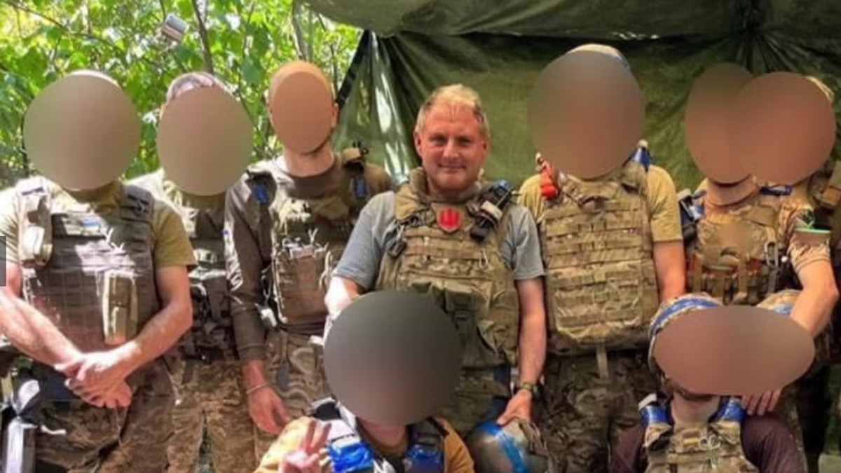 Jack Lopresti, central, fata neblurata, in mijlocul unor luptători din Legiunea Internațională care luptă în Ucraina