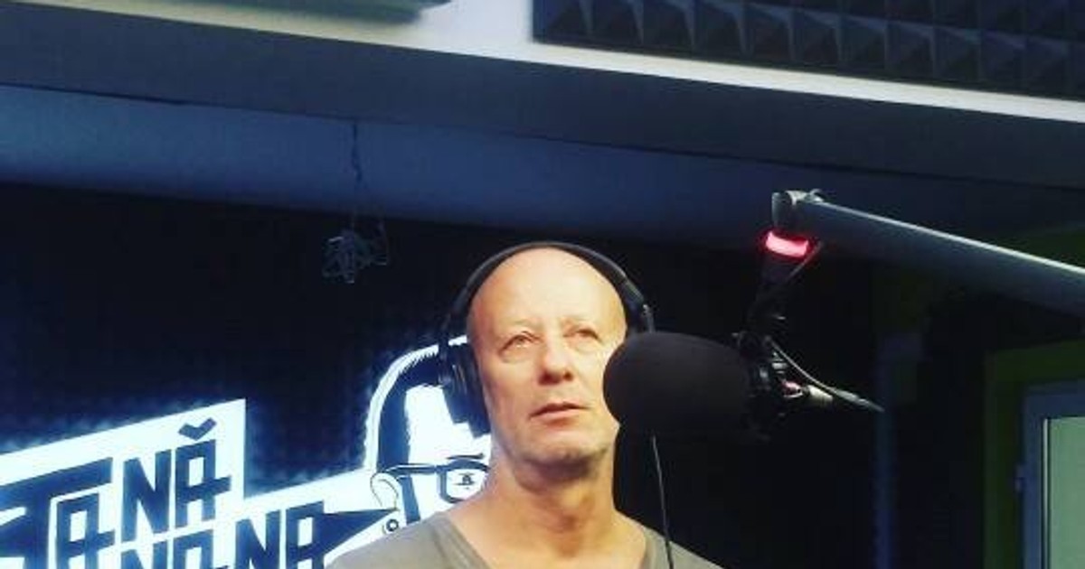 Andrei Gheorghe, cu căștile pe urechi, vorbește la microfon, într-un studio radio