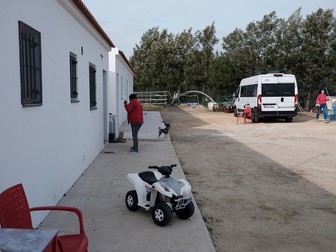 Redacția Teleleu (autorulota albă) parcată la cazări, într-un câmp de căpșuni din Palos de la Frontera. În dreapta, Elena Stancu, jurnalistă la Teleleu.eu și Libertatea, iar în stânga Tina, cățelul Teleleu