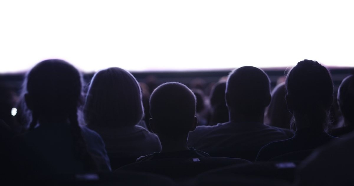 Captură din mijloc cu siluete de oameni din spate care se uită la cinema sau spectacole cu un spațiu gol alb
