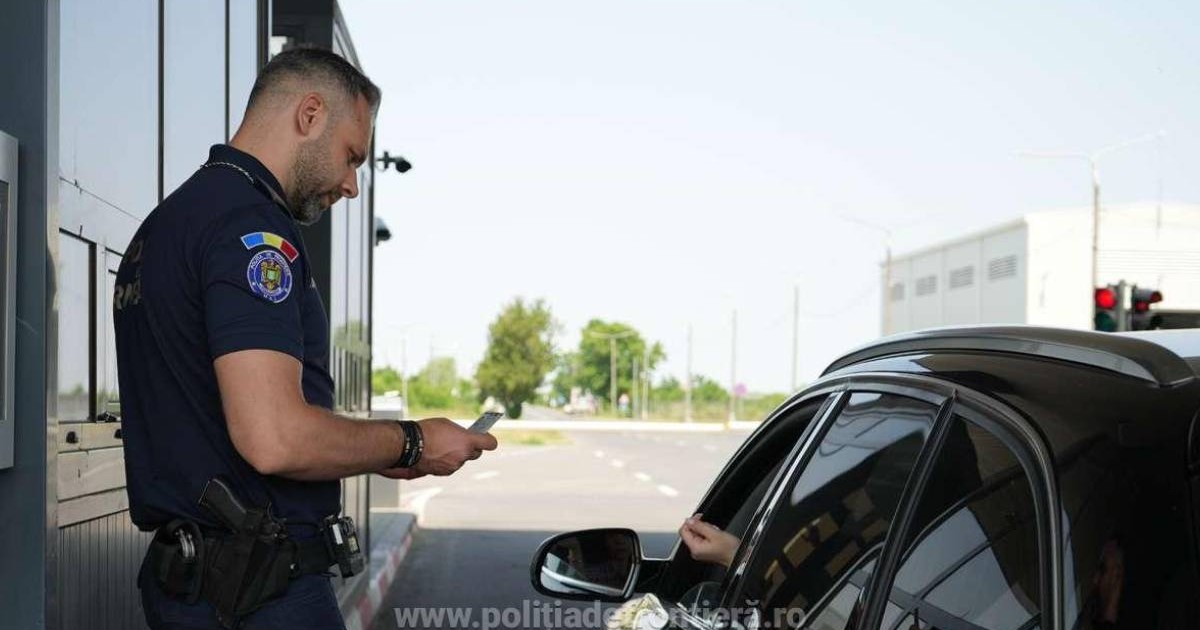 Imagine cu un polițist de frontieră care verifică actele unui șofer care se află într-o mașină neagră
