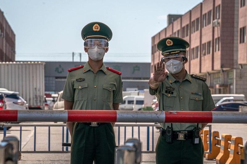 Polițiștii paramilitari stau de pază în piața Xinfadi din Beijing, locul unde a izbucnit un nou focar de infecție FOTO: EPA
