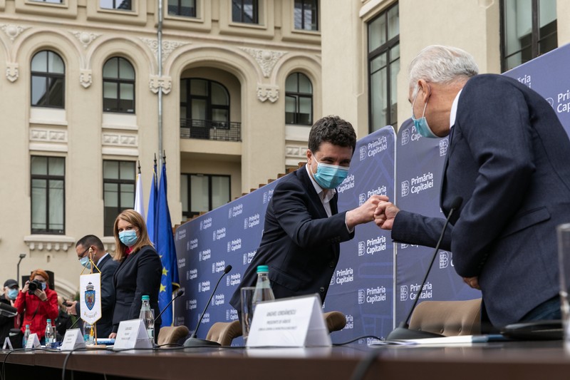 Noul primar își exersează salutul pandemic cu Anghel Iordănescu, care la 70 de ani este decanul de vârstă al Consiliului General