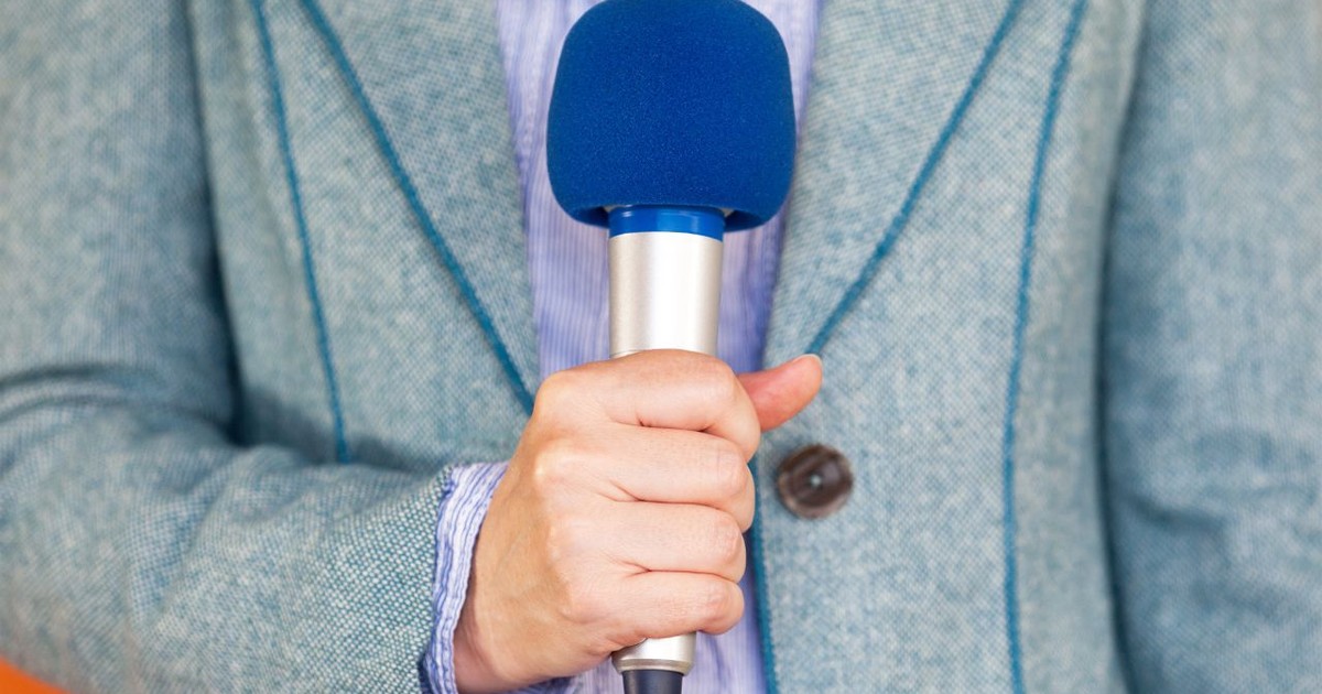 un reporter ține un microfon