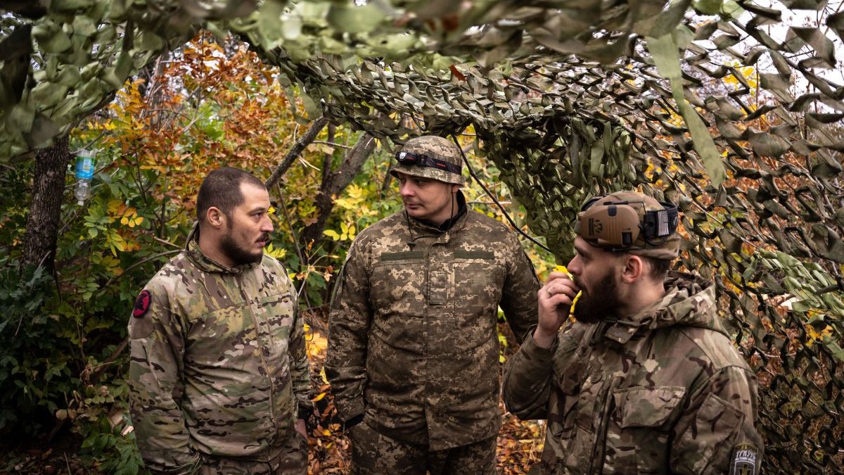 Trei soldați ucraineni discută între ei într-un moment de respiro