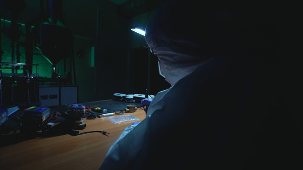 Un cercetător în combinezon, într-un laborator improvizat