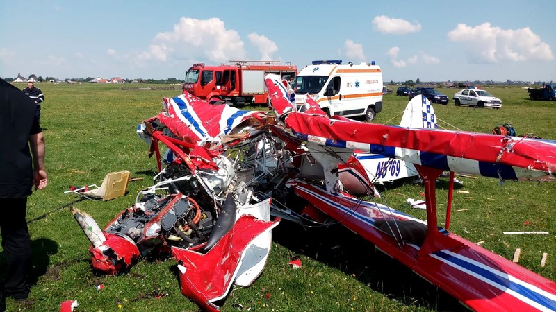 Fotografie de la locul prăbușirii celor dou avioane. În imagine apare unul dintre aeronave, roșu cu alb, iar în spate o ambulanță și o mașină de pompieri