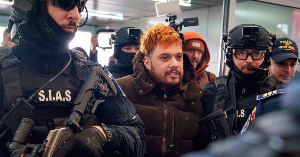 Mohamed Amra, poreclit „Musca”, este escortat de ofițeri de poliție înarmați pe aeroportul internațional Henri Coandă din Otopeni, România, marți, 25 februarie 2025, înainte de a fi extrădat în Franța.