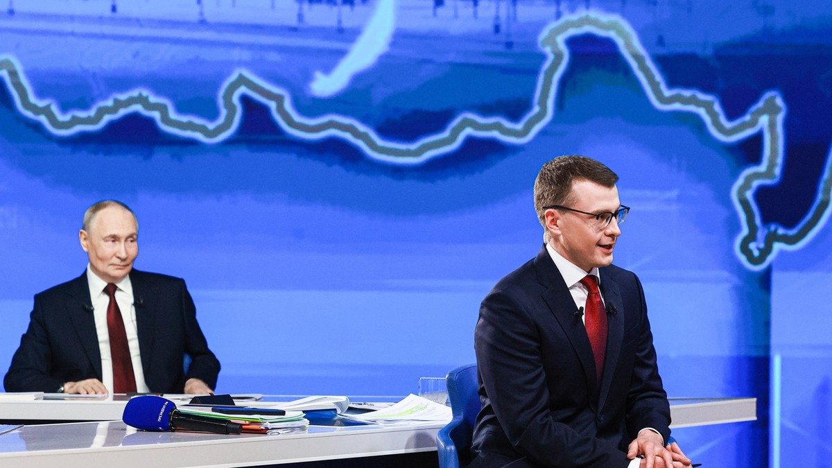 Pavel Zarubin, în prim-plan, este surprins în timp ce moderează Linia directă cu Vladimir Putin, aflat în spatele său Foto: Profimedia