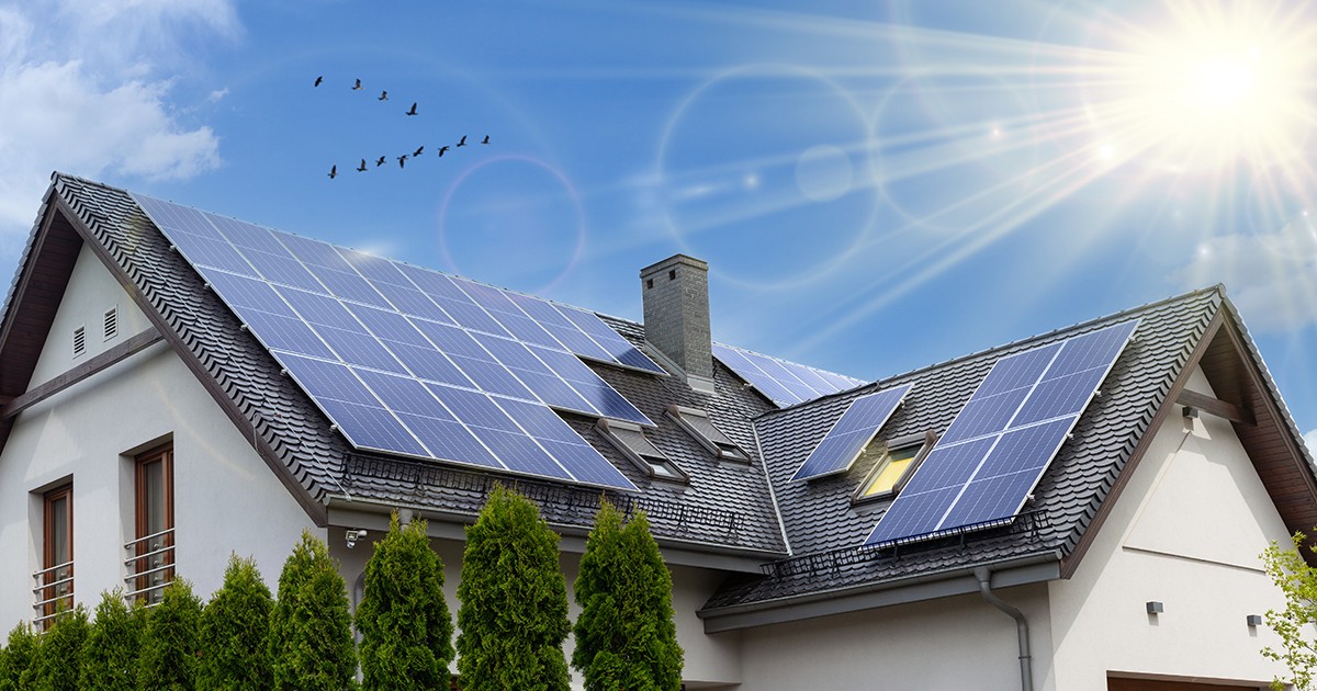 Panouri solare pe un acoperiș în două ape. Casă modernă frumoasă, mare și energie solară. Razele soarelui.