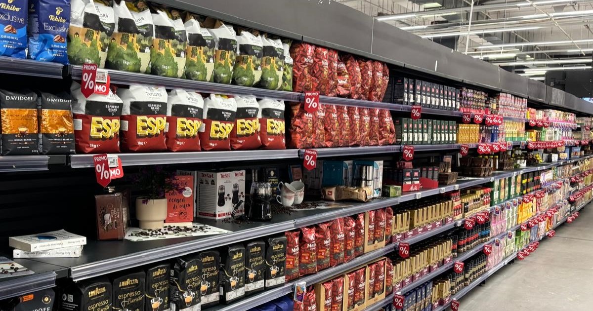 Târgul de Cafea și Ceai la Auchan. Pachete șii pungi de cafea pe rafturi, într-un supermarket.