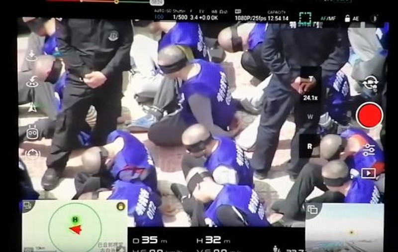 Sute de oameni cu cătușe și legați la ochi, filmați cu drona în China. Ar fi fost duși în lagăre de concentrare