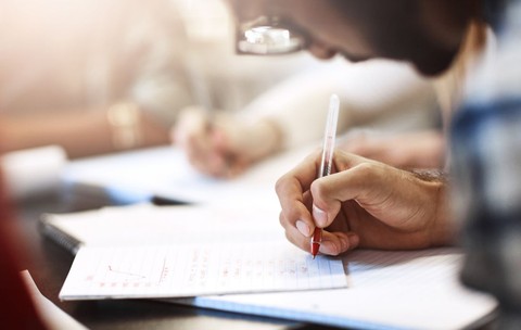 Elev scriind în timpul examenului