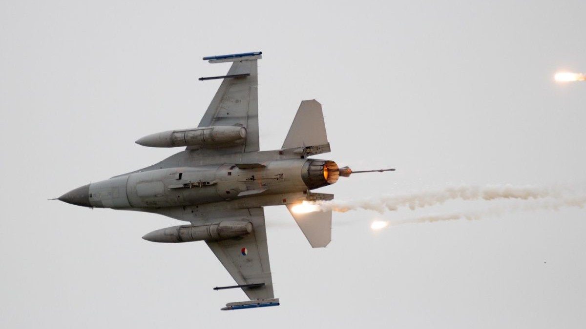 Un avion F-16 în zbor trage cu rachete de semnalizare