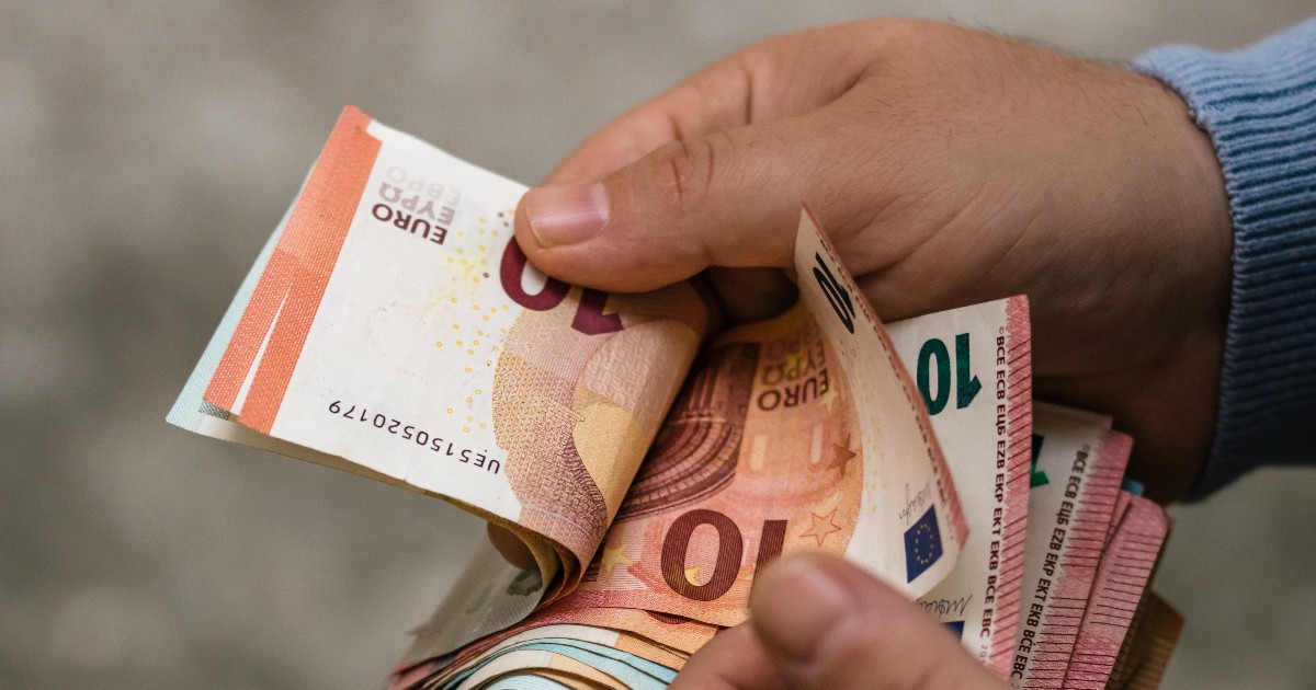 Un bărbat care numără bancnote euro.