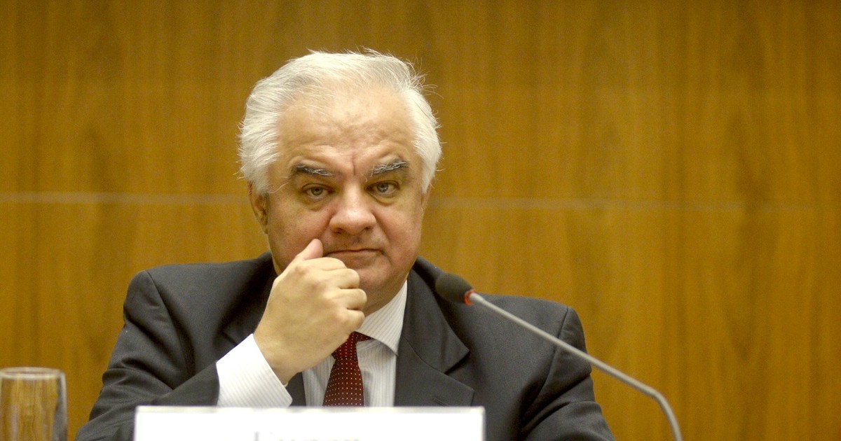 Eugen Rădulescu, consilier BNR, la costum, într-o sală de conferințe, în fața unui microfon