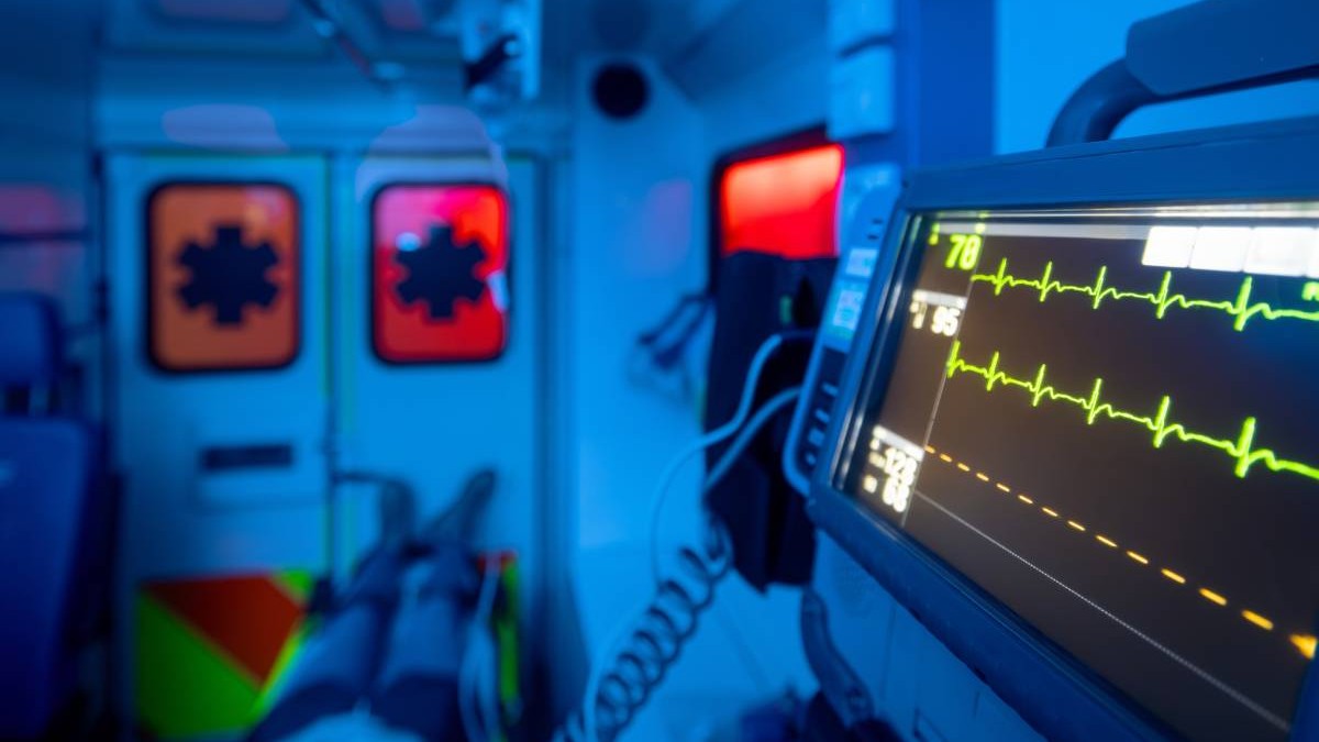 Un bărbat care stă pe targă în ambulanța și este dus la spital