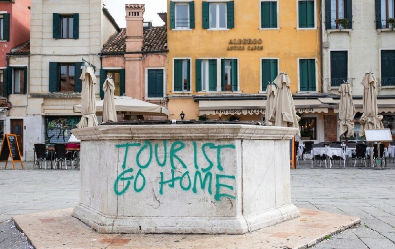 Protest împotriva turismului excesiv, slogan pulverizat pe o fântână, Campo Santa Margerita, Veneția, Italia, Europa