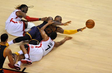 epa05325885 Cleveland Cavaliers forward LeBron James tries to pass the ball after colliding with Toronto Raptors forward DeMarre Carroll (L) and guard Kyle Lowry during the fourth quarter of game four in the NBA Eastern Conference basketball finals at the Air Canada Center in Toronto, Canada, 23 May 2016. The Raptors defeated the Cavaliers 105-99. EPA/WARREN TODA CORBIS OUT