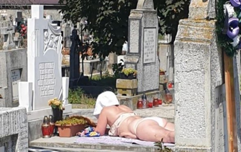 La plajă, într-un cimitir din Alba Iulia. O femeie şi-a întins pătura pe un mormânt