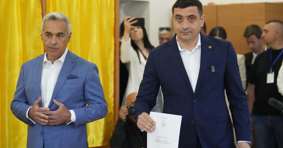 Candidatul AUR la prezidențiale George Simion (dreapta) introduce în urnă buletinul de vot și se află lângă Călin Georgescu, câștigătorul primului tur al alegerilor anulate de anul trecut, Mogoșoaia, duminică, 4 mai 2025.