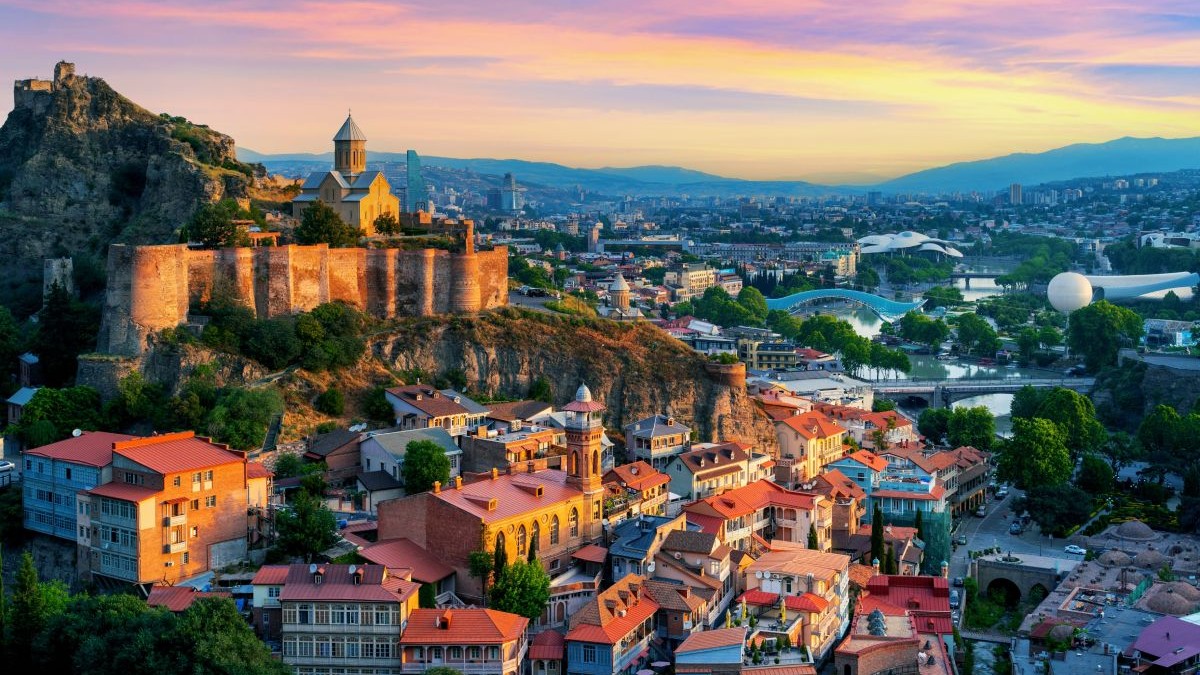 Imagine aeriană, la apus, cu orașul Tbilisi din Georgia, cu clădiri impunătoare care se văd în orizont