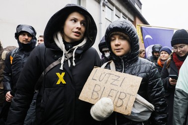 Greta Thunberg, în dreapa, cu o bucată de carton pe care scrie „Lützerath continuă”