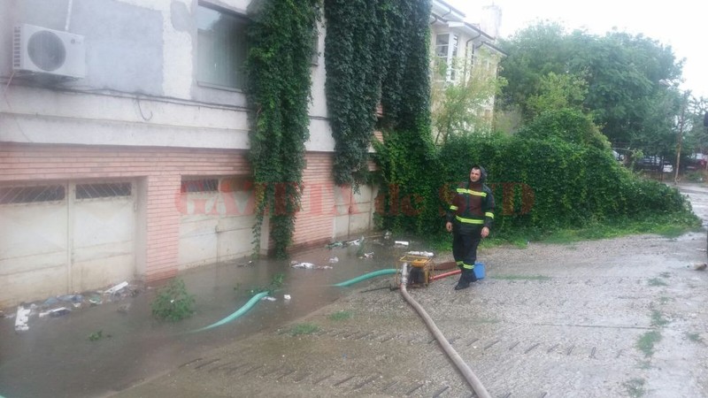 Pompierii ISU Olt evacuează apa cu motopompele dintr-o clădire inundată sursă foto: gds.ro