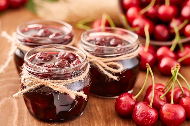 Cherry jam on wooden ground with fresh cherries