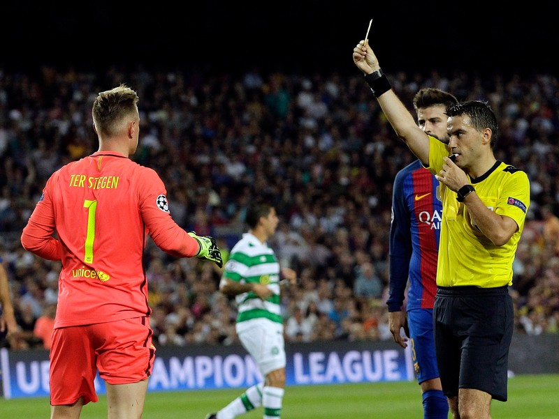 Romanian referee Ovidiu Hategan (R) shows a yellow card to FC Barcelona's goalkeeper Marc-Andre ter Stegen during the UEFA Champions League Group C soccer match beween FC Barcelona and Celtic Glasgow at Camp Nou stadium in Barcelona, Catalonia, Spain, 13 September 2016. EPA/ALBERTO ESTEVEZ
