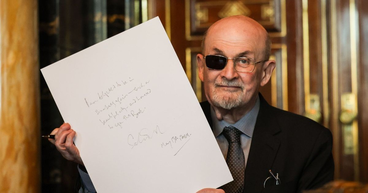 Scriitorul indiano-britanic Salman Rushdie arată textul său după ce a semnat în Cartea de Aur a orașului, 13 mai 2024