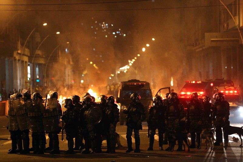 epa03752348 A group police officers stand in the main street of Niteroi, a city close to Rio de Janeiro, Brazil, 19 June 2013, during a protest against the rise of public transport prices and the expenses made by the Brazilian government for the FIFA Confederations and World Cups. EPA/MARCELO SAYAO